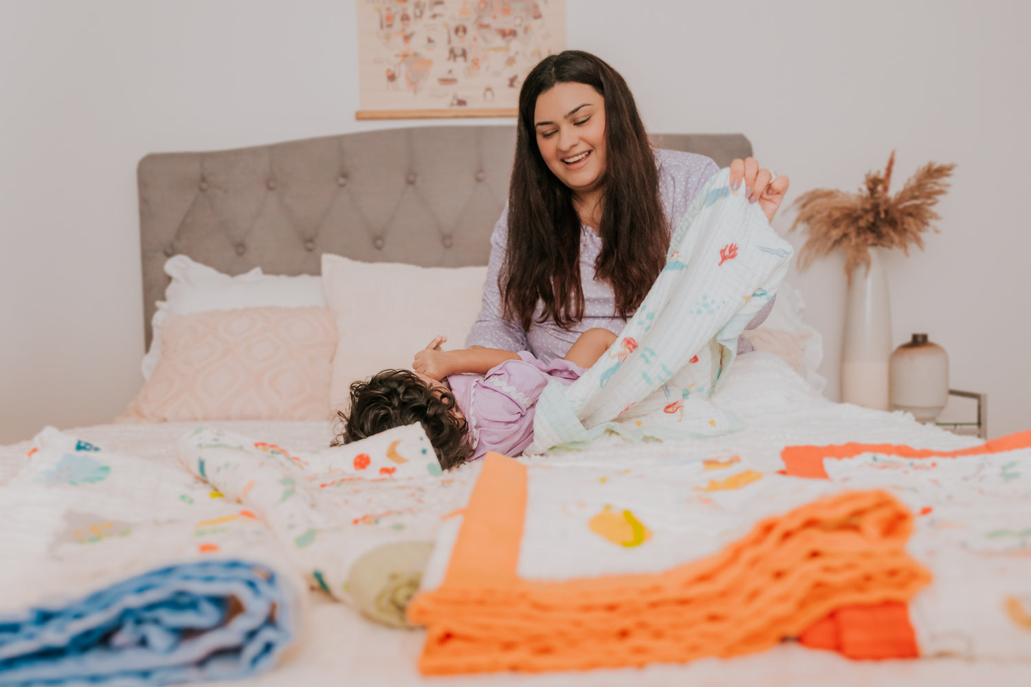 A mother is making her baby sleep in the blanket