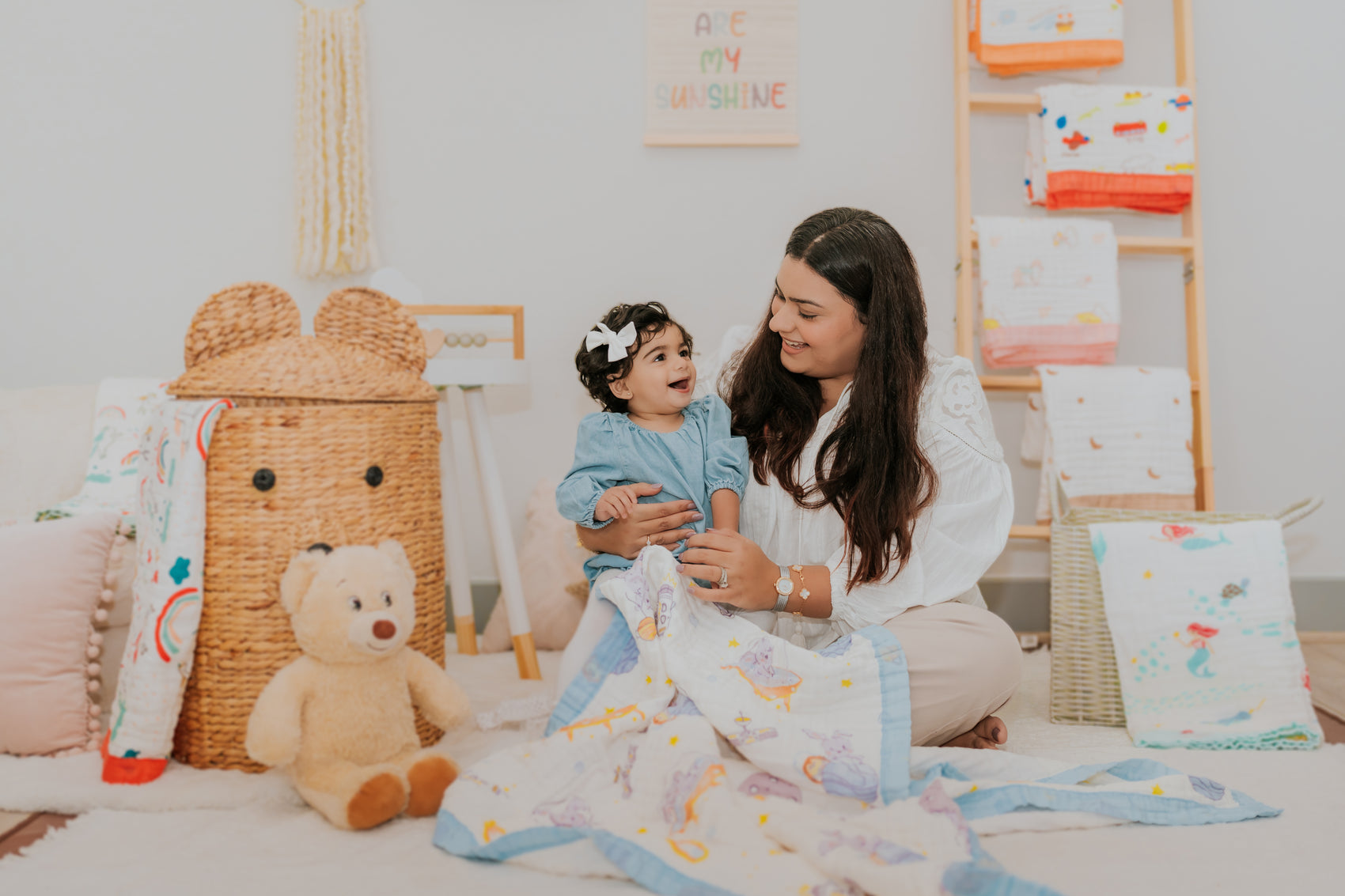 baby and mother playing in blanket