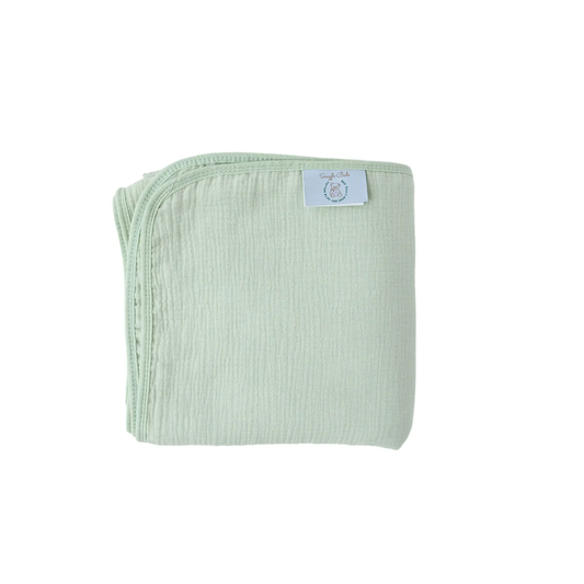 Baby wrapped in a light green blanket on a textured surface