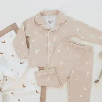 Children's pajama set with moon and star pattern on a white background